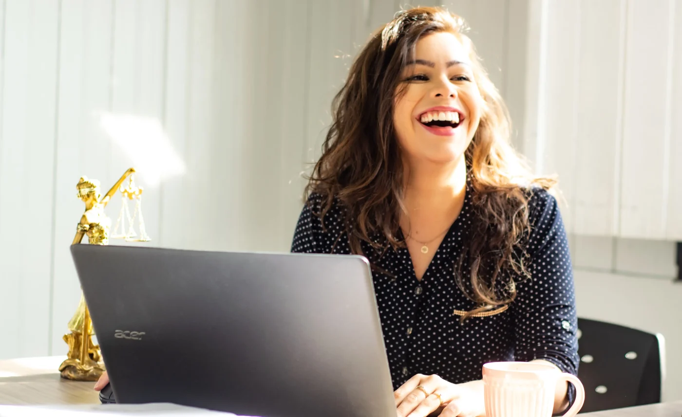 une femme souriante travaillant sur son ordinateur